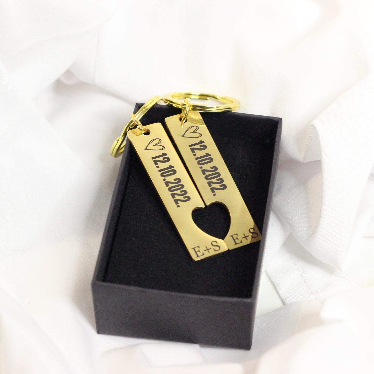 Dāvana vīrietim - atslēgu piekariņš pāriem zelta krāsā ar datuma un iniciāļu gravējumiem.