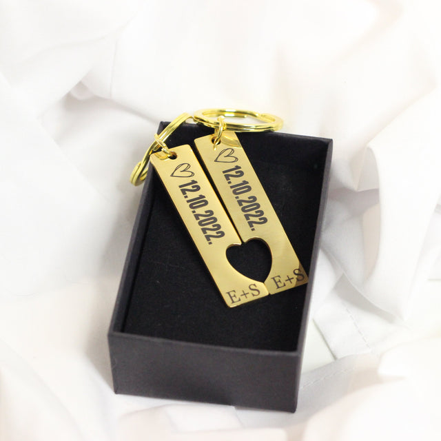 Dāvana vīrietim - atslēgu piekariņš pāriem zelta krāsā ar datuma un iniciāļu gravējumiem.