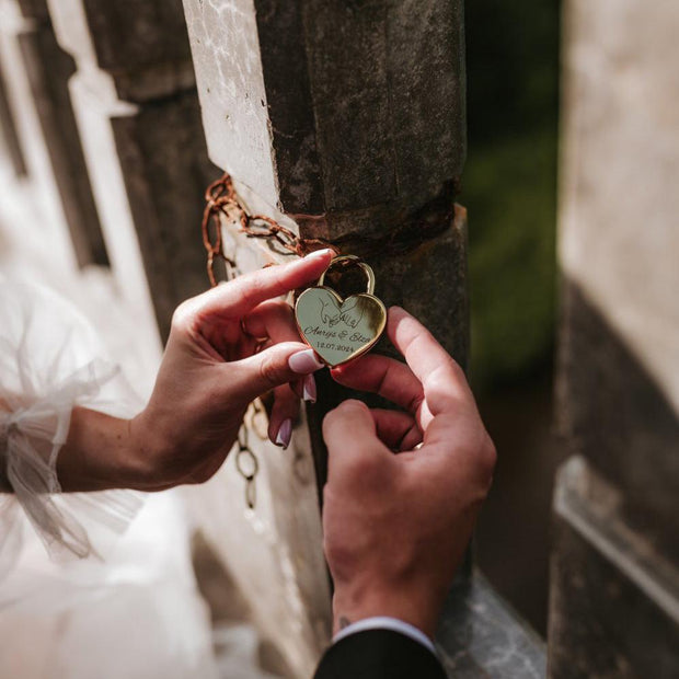 Līgava un līganainis pieastiprina kāzu slēdzeni pie tilta margas